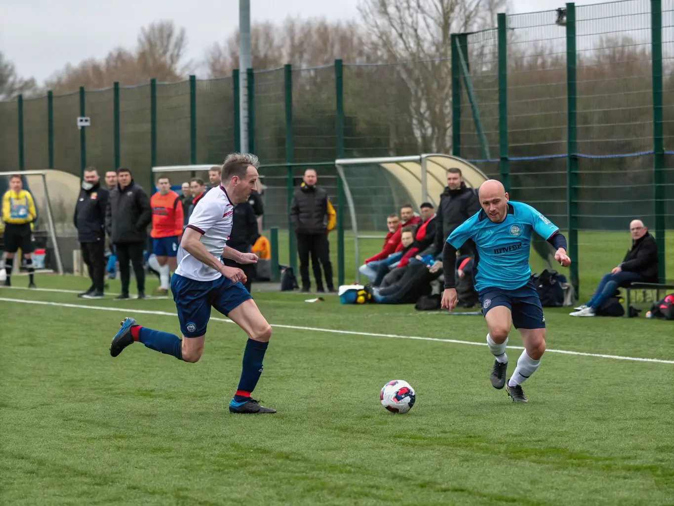 A dynamic shot of adult players in ESCQ jerseys competing in a league match, showcasing the competitive spirit and camaraderie of the adult soccer leagues.